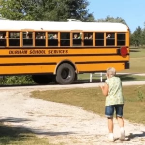 A school bus packed of kids stops for a little while to make grandma’s day.